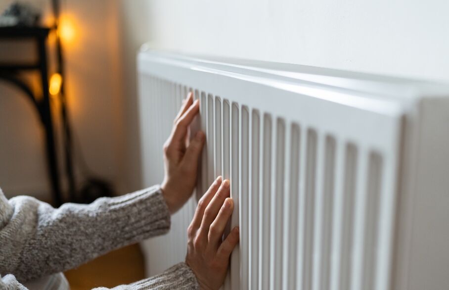 A person's hands on a radiator