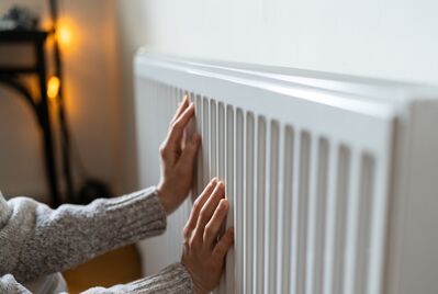 A person's hands on a radiator