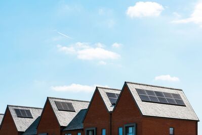 A row of houses with solar panels on their rooves