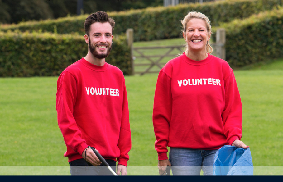 Two people holding a litter picker and bag for litter picking week