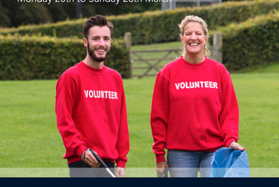 Two people holding a litter picker and bag for litter picking week