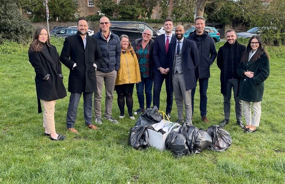 A group of people gathered around litter bags