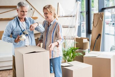 A couple packing up a cardboard box