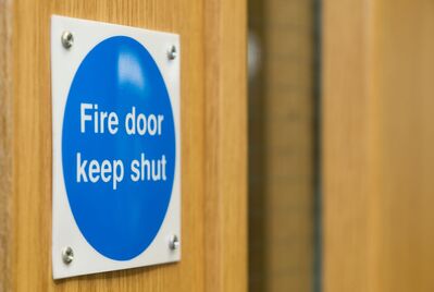 A sticker on a door that says Fire door keep shut
