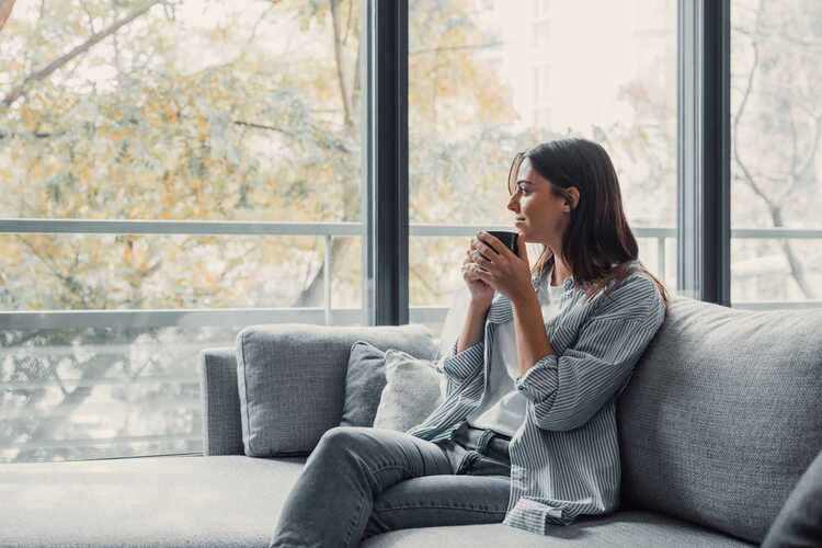 A woman sits on a sofa