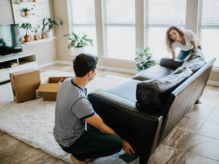 Couple moving sofa in new house