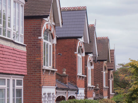 A row of large British brick terraced houses in residential area of Wimbledon