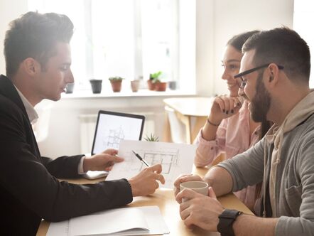 Young couple speaking with an estate agent