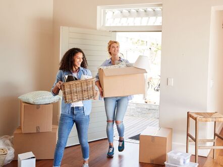 couple moving box as they move into house